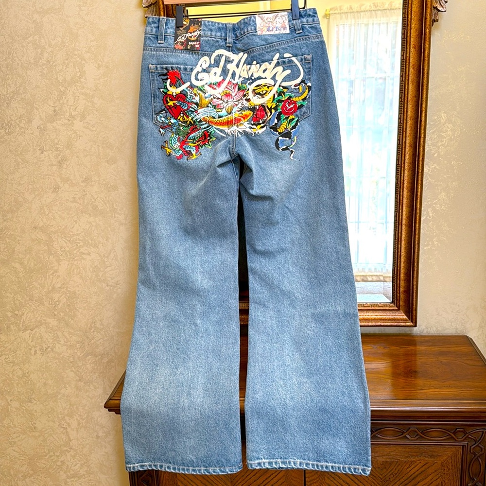 New Ed Hardy Baggy blue Jeans. Sz 30. Ed Hardy collage of pictures on rear.
